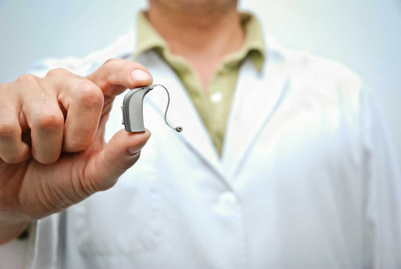 audiologist holding hearing aid