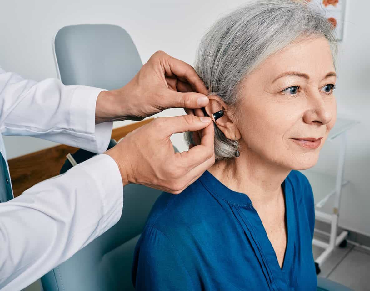 Woman getting hearing aid installed